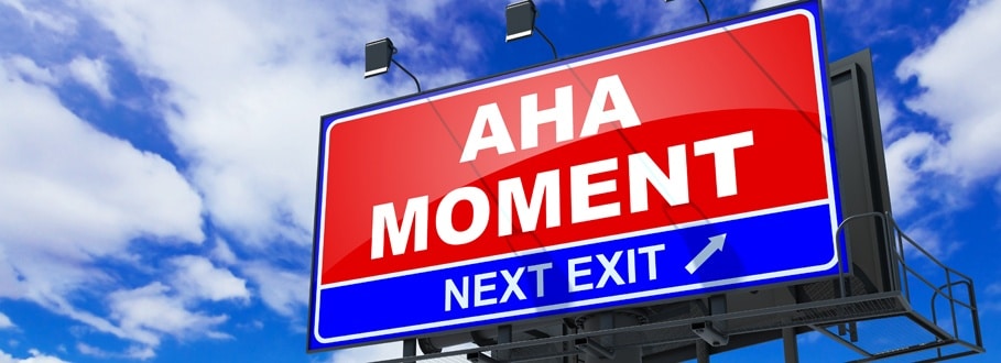red billboard that says aha moment next exit with blue sky