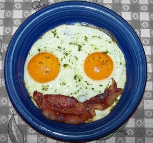 bacon and eggs on a plate (arranged like a smiley face)