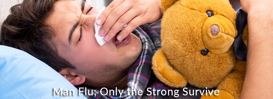 grown man with the flu holding a teddy bear and a tissue