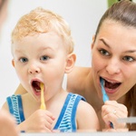 mother and child brushing teeth