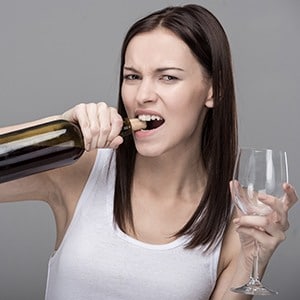 woman opening a wine bottle with her teeth