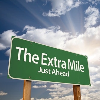the extra mile just ahead green road sign