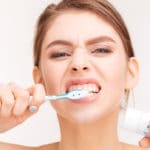 woman aggressively brushing her teeth