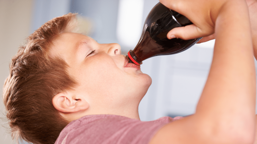 young man drinking a bottle of soda