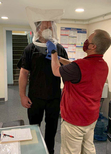 Dr. Peter drews getting fitted to ensure his N95 mask fits like it should