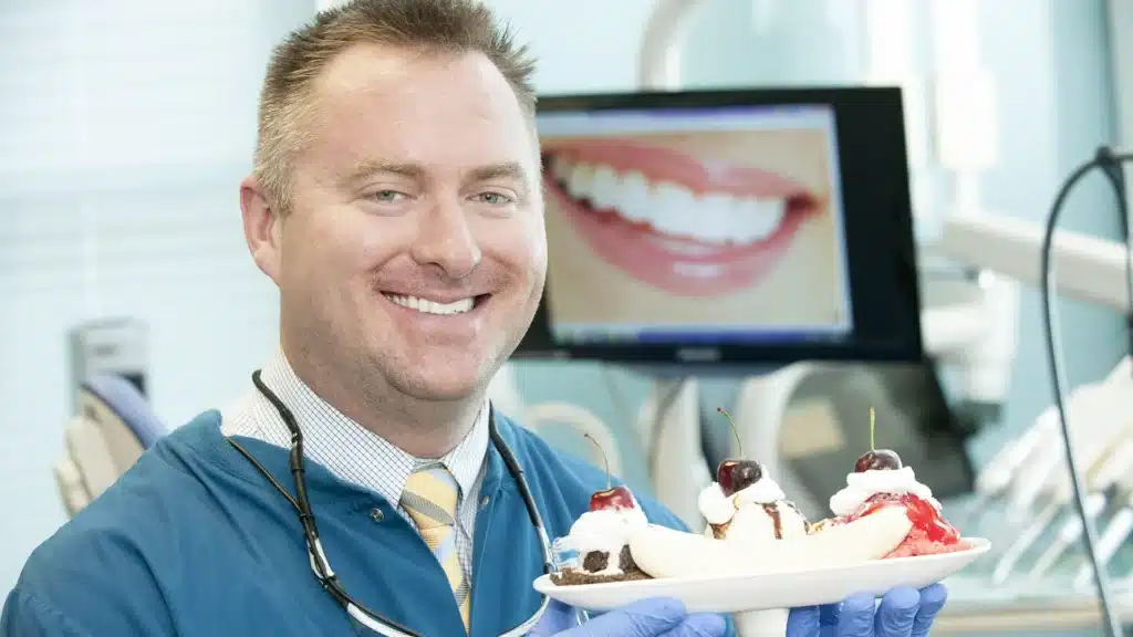 Dr. Peter Drews at Drews Dental holding a banana split in the new office