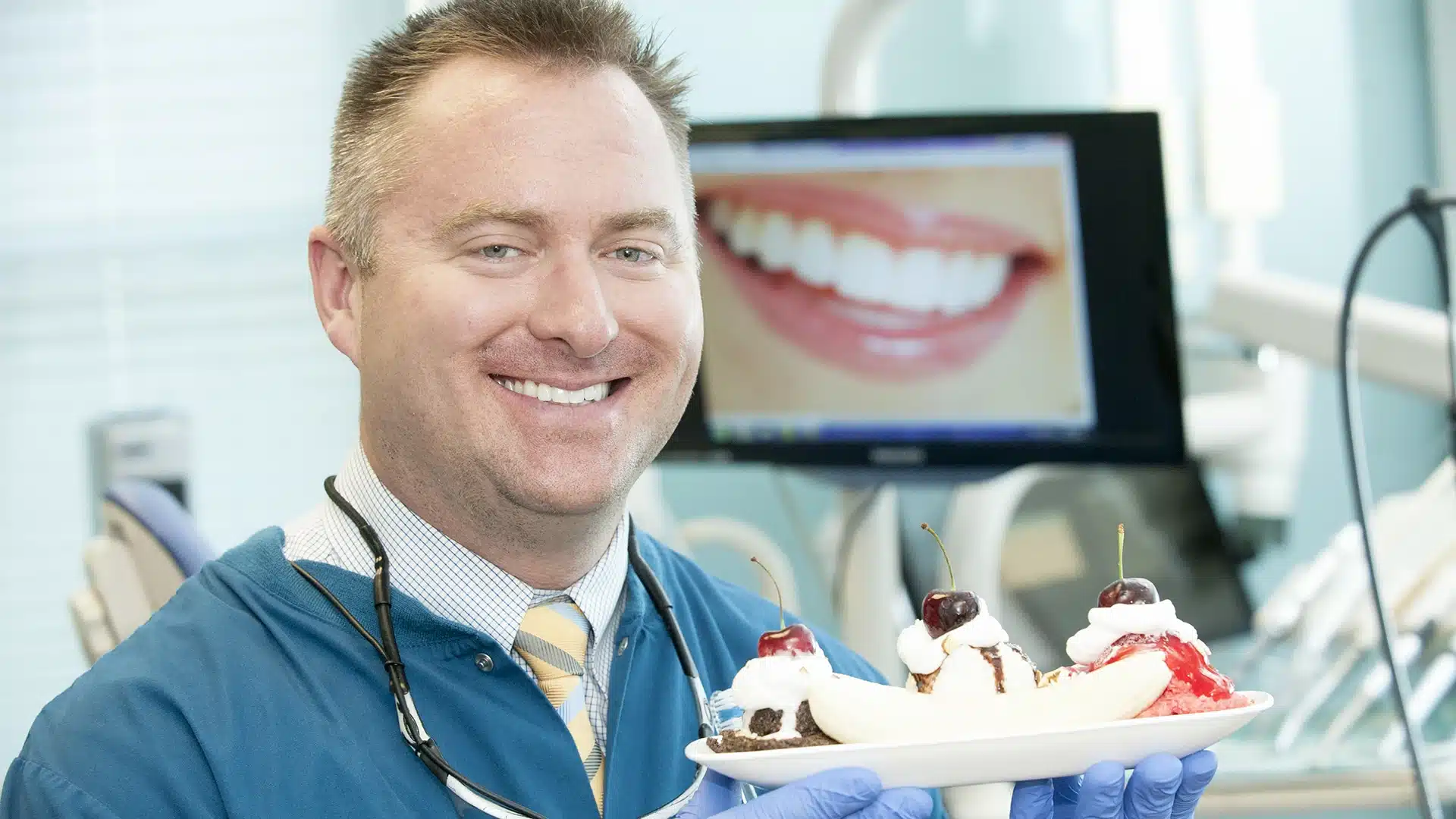 Dr. Peter Drews at Drews Dental holding a banana split in the new office
