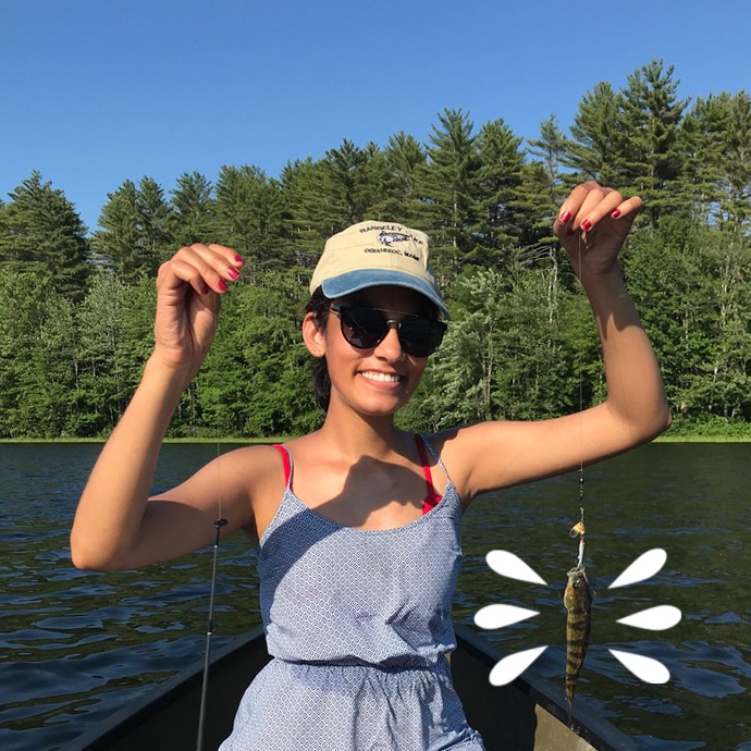 Dr. Hena Patel posing with the fish she caught on a beautiful Maine day at the lake