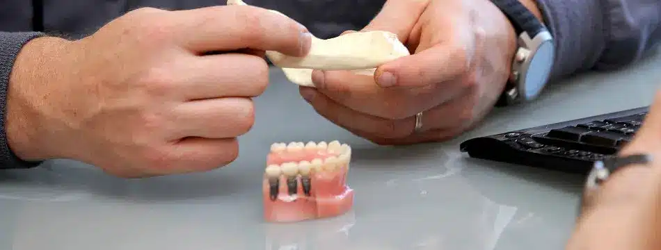 Dr. Drews holding a dental implant model