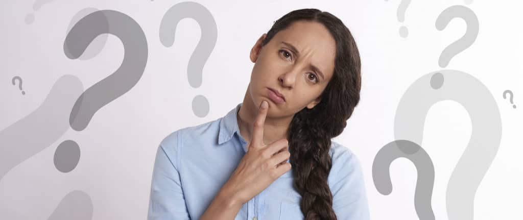 inquisitive woman in front of a background full of question marks