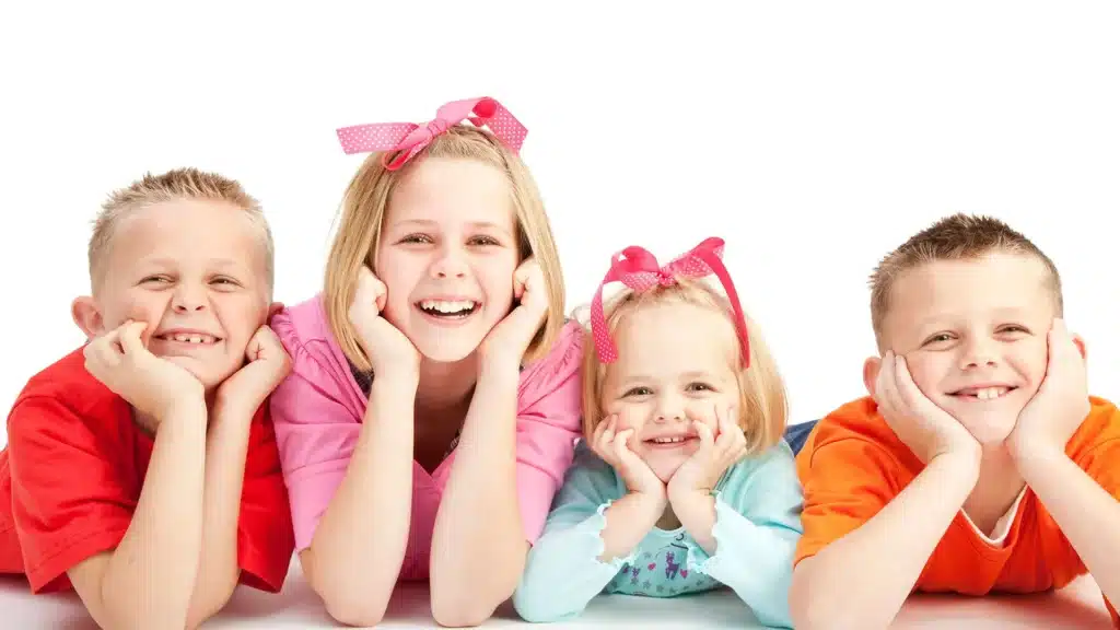 four smiling kids looking towards the camera