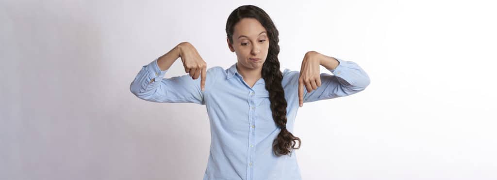 woman pointing downward with both hands