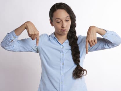 woman pointing downward with both hands