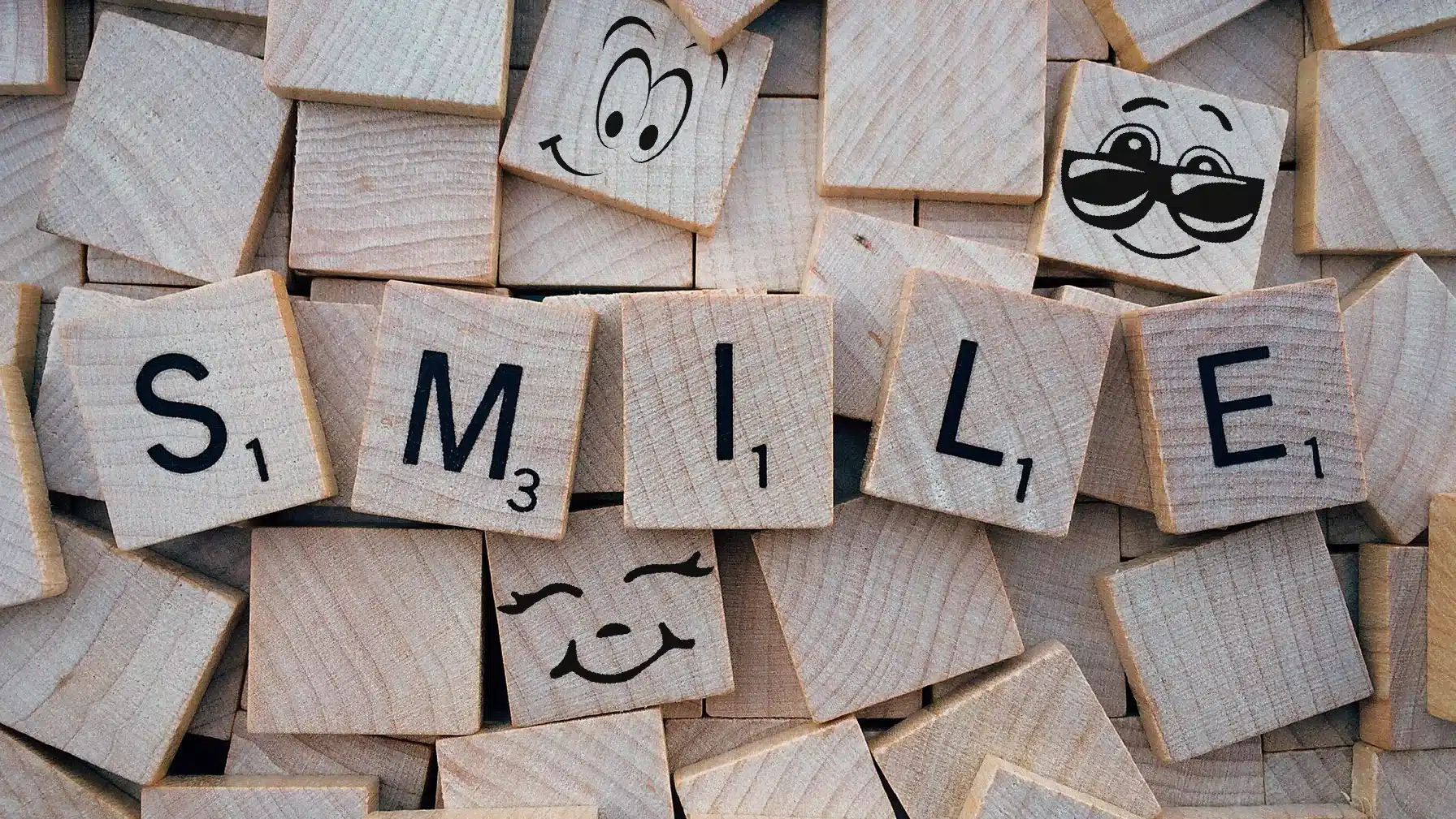 the word smile spelled out of scrabble letter tiles