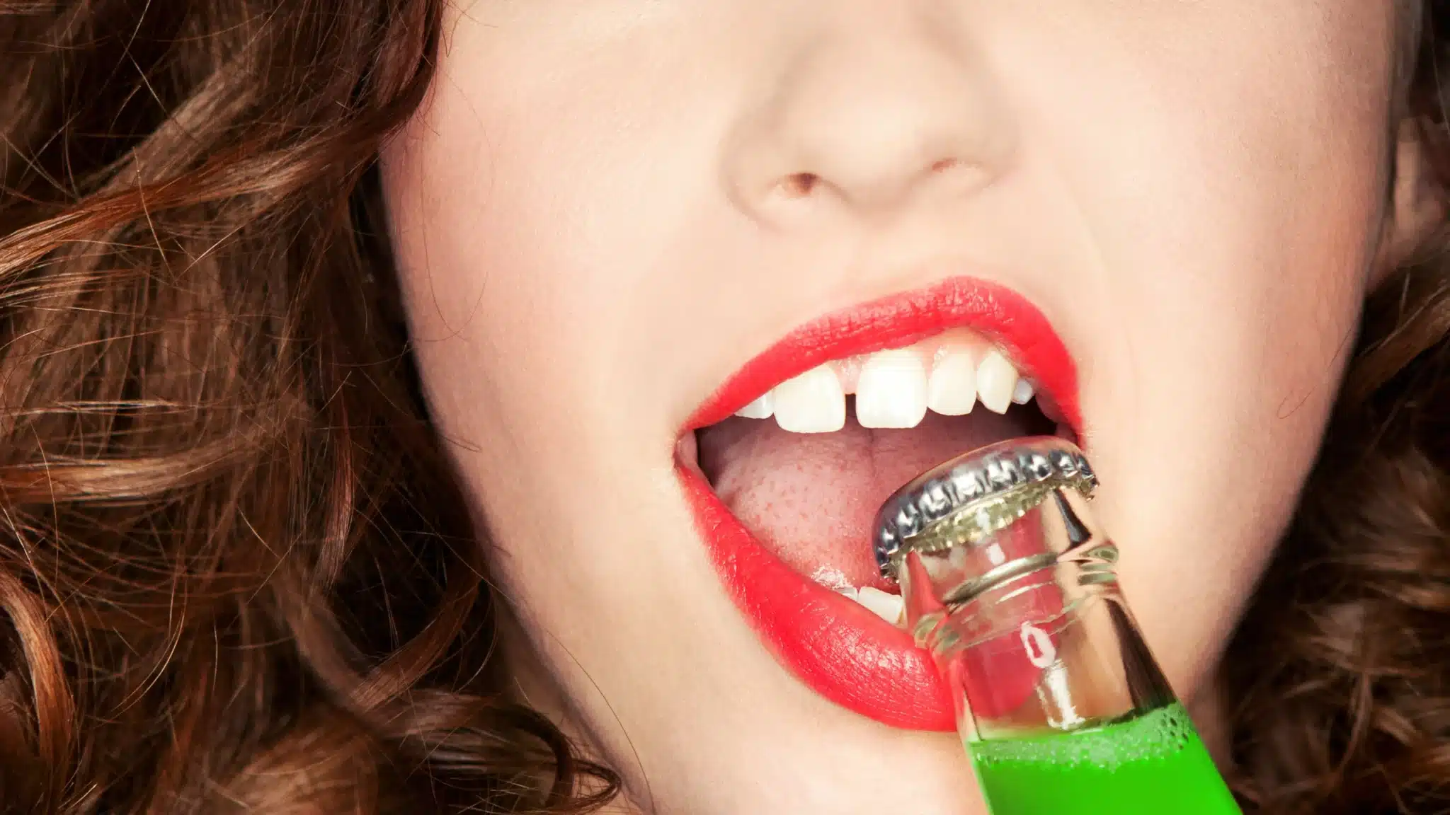 woman using her teeth as a substitute bottle opener