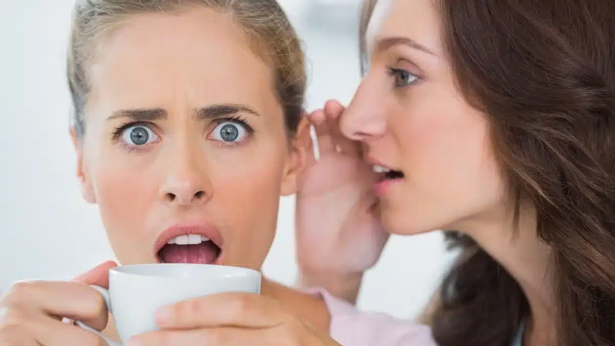 woman whispering a secret to her friend