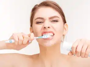 woman aggressively brushing her teeth