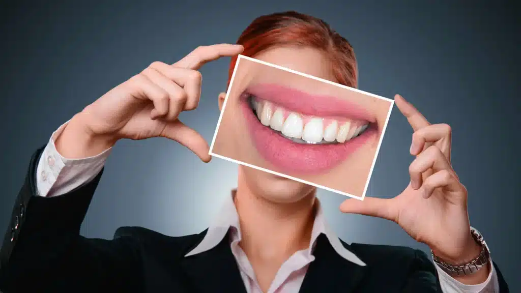 woman holding a photo of a smile over her face